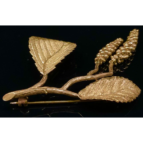 1331 - A 9ct gold hazel brooch, formed as a delicate branch bearing leaves and catkins, 8cm long, 11.7g