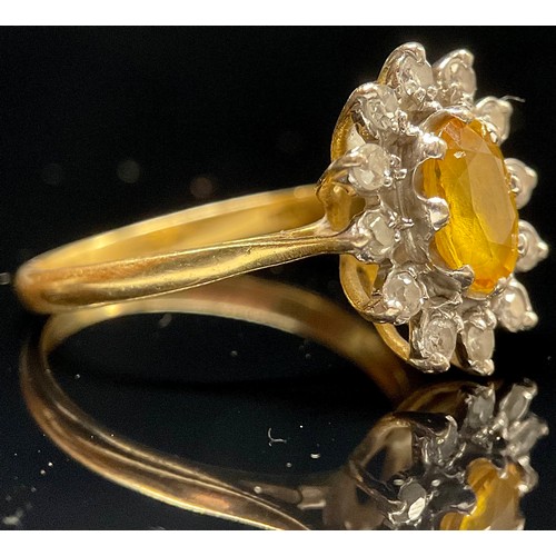 1383 - A diamond, yellow sapphire and 18ct gold cluster ring, central oval raised claw set stone within twe... 