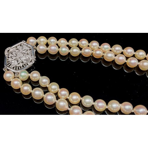 1450 - A two strand pearl necklace, each approximately 7mm diameter, the hexagonal white metal clasp stampe... 