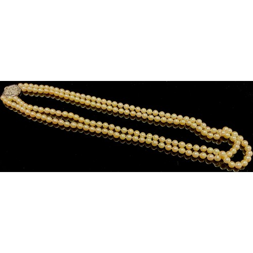 1450 - A two strand pearl necklace, each approximately 7mm diameter, the hexagonal white metal clasp stampe... 