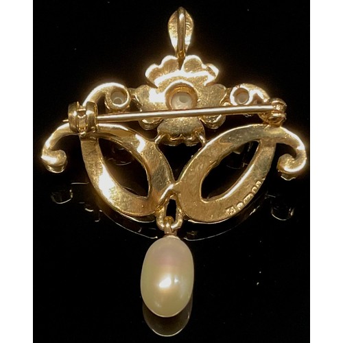 1517 - An Edwardian style pearl and 9ct gold pendant brooch, the flower head and open work sinuous scrolls ... 