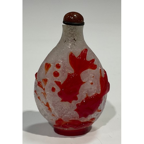 401 - A Chinese Peking glass ovoid snuff bottle, decorated in red overlay with fantail fish against a snow... 