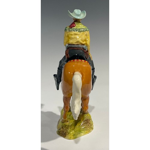 25 - A Beswick model of a Canadian Mounted Cowboy on a galloping Palomino horse, number 1377, 22.5cm, pri... 