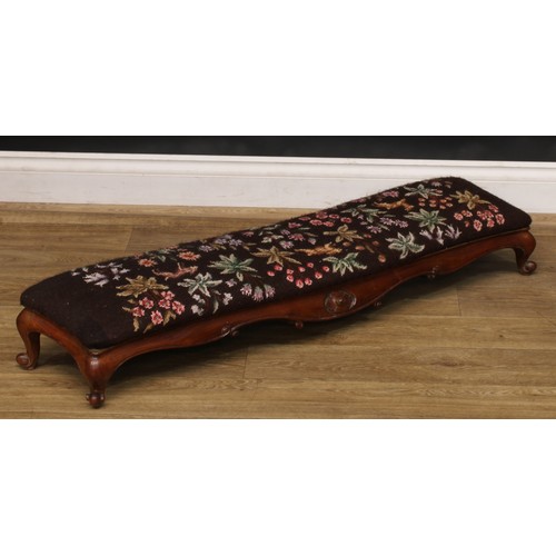 2295 - A Victorian walnut sofa-length serpentine footstool or hearth stool, shaped apron carved with scroll... 