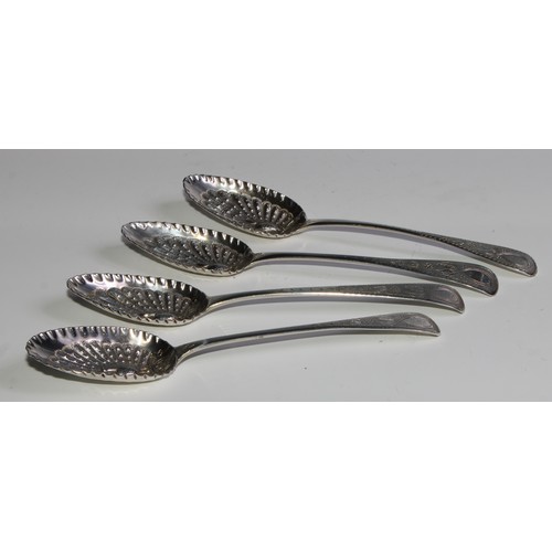 800 - A set of four George III silver Old English pattern berry spoons, the bowls unusually chased with pe... 