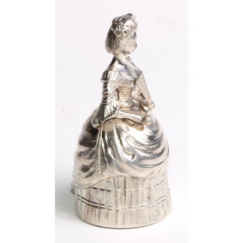 880 - A Continental silver novelty table bell, cast as a lady of title, elegantly dressed and holding a fa... 