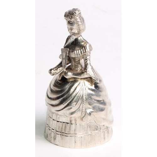 880 - A Continental silver novelty table bell, cast as a lady of title, elegantly dressed and holding a fa... 