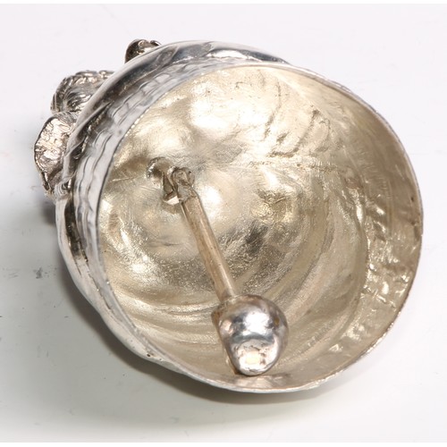 880 - A Continental silver novelty table bell, cast as a lady of title, elegantly dressed and holding a fa... 