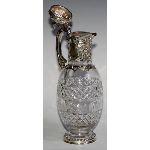 1097 - A Victorian silver ovoid claret jug, hinged cover and mount chased with scrolling leaves and fruitin... 