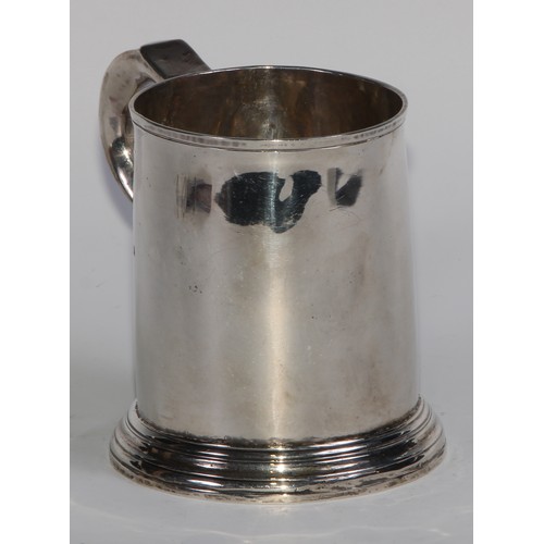 901 - A George II silver cylindrical mug, quite plain, scroll handle with whistle terminal, skirted base, ... 