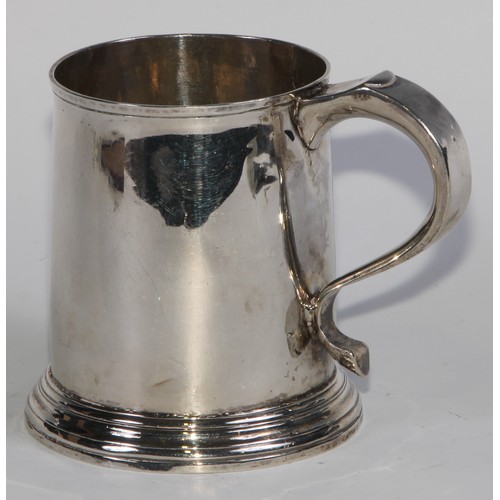 901 - A George II silver cylindrical mug, quite plain, scroll handle with whistle terminal, skirted base, ... 