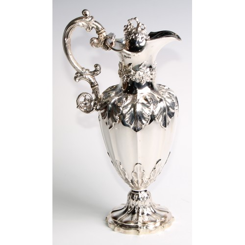 1091 - A Victorian silver fluted pedestal wine ewer, profusely chased with fruiting vine, hinged cover, 32.... 