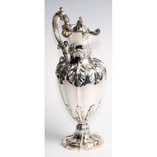 1091 - A Victorian silver fluted pedestal wine ewer, profusely chased with fruiting vine, hinged cover, 32.... 