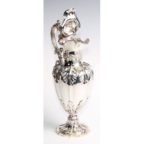 1091 - A Victorian silver fluted pedestal wine ewer, profusely chased with fruiting vine, hinged cover, 32.... 