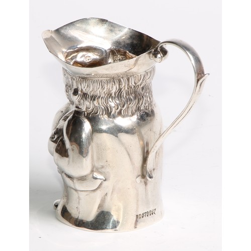 963 - A George V silver novelty cream pitcher, as a toby jug, modelled after a Staffordshire pottery model... 