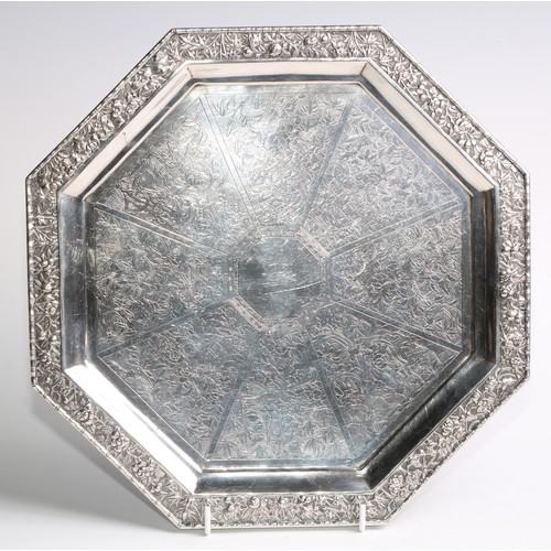 864 - A Chinese silver octagonal salver, profusely chased and engraved with chrysanthemums, bamboo and blo... 