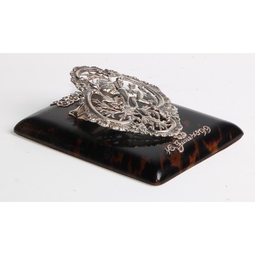 1084 - A Victorian silver and tortoiseshell rectangular desk clip, pierced and cast with a putto at a bird'... 