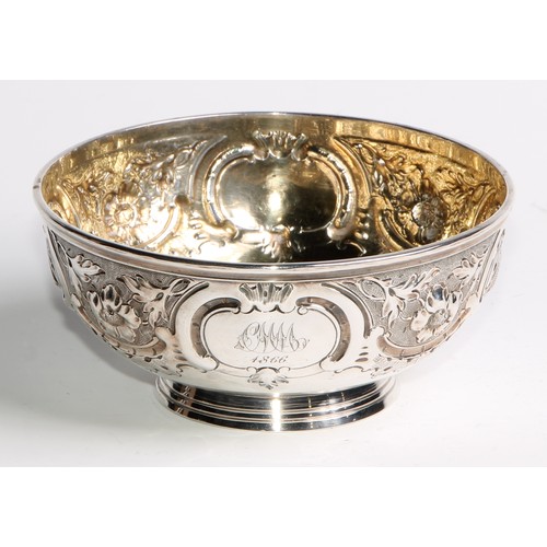 1087 - A Victorian silver circular footed bowl, chased with flowers, leaves, shells and scrolls, gilt inter... 