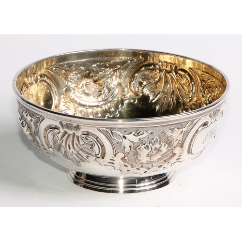 1087 - A Victorian silver circular footed bowl, chased with flowers, leaves, shells and scrolls, gilt inter... 