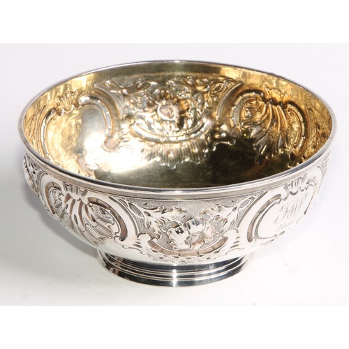 1087 - A Victorian silver circular footed bowl, chased with flowers, leaves, shells and scrolls, gilt inter... 