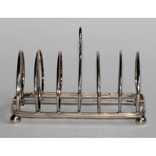 948 - A George IV Provincial silver seven-bar toast rack, ring handle, arched doubler-loop divisions, ball... 