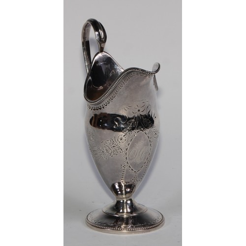 911 - A George III Scottish silver helmet shaped pedestal cream jug, bright-cut engraved in the Neo-Classi... 