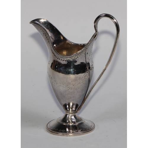 911 - A George III Scottish silver helmet shaped pedestal cream jug, bright-cut engraved in the Neo-Classi... 