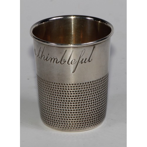 1125 - An American silver novelty whisky tot or stirrup cup, as a thimble, inscribed Just a Thimbleful, gil... 