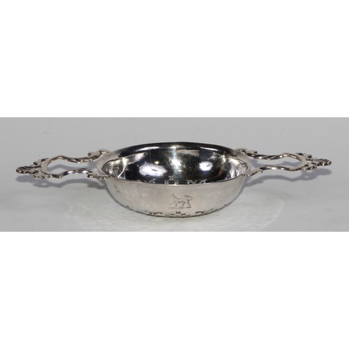 903 - A George II silver lemon strainer, shaped lug handles crested by shells, 19cm wide, London 1741, 80g