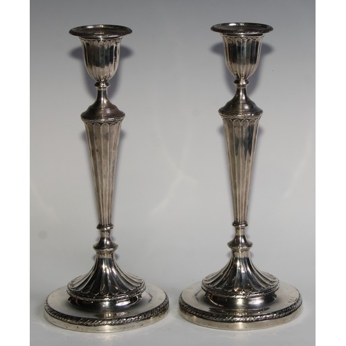 1038 - A pair of Victorian silver table candlesticks, in the Adam Revival taste, urnular sconces with detac... 