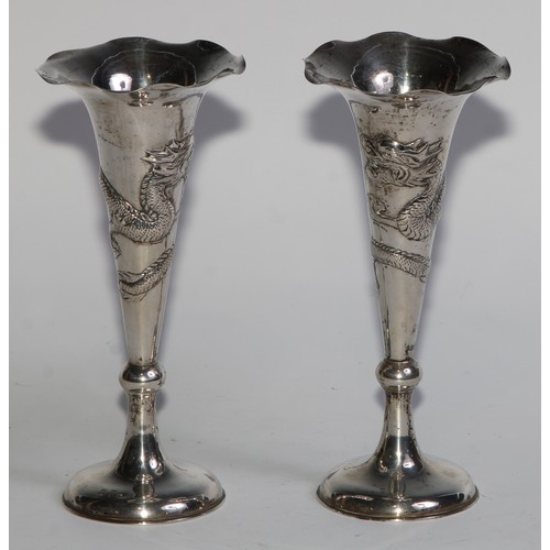 1013 - A pair of Chinese silver trumpet shaped specimen vases, chased with dragons, domed bases, 15cm high,... 