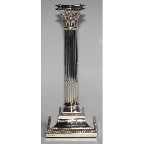 1021 - A pair of Edwardian silver stop-fluted Corinthian column candlesticks, detachable nozzles, gadrooned... 