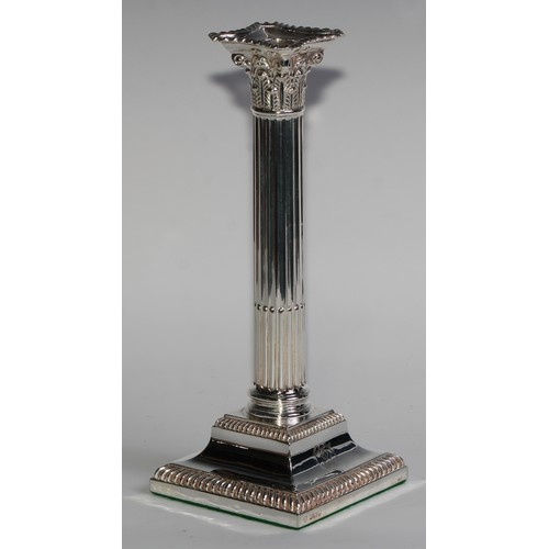 1021 - A pair of Edwardian silver stop-fluted Corinthian column candlesticks, detachable nozzles, gadrooned... 