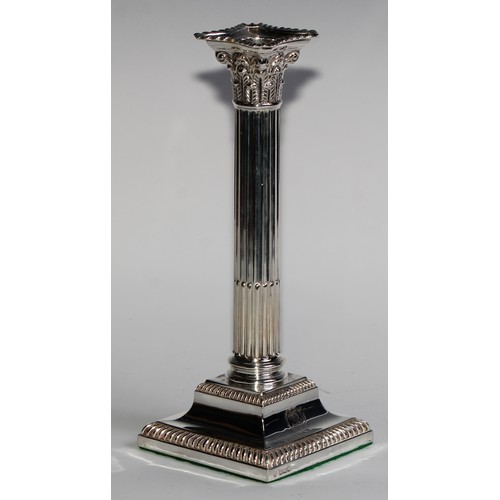 1021 - A pair of Edwardian silver stop-fluted Corinthian column candlesticks, detachable nozzles, gadrooned... 