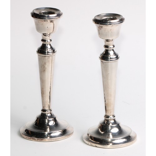 1022 - A pair of Elizabeth II silver candlesticks, urnular sconces, tapered pillars, circular bases, 19cm h... 