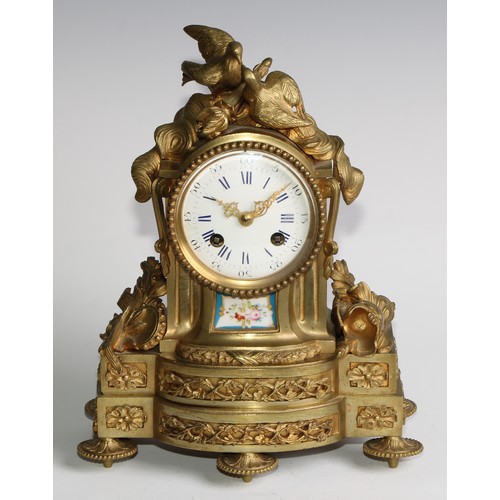 1754 - A French gilt brass mantel clock, crested with a pair of lovebirds and flaming torch, the white enam... 