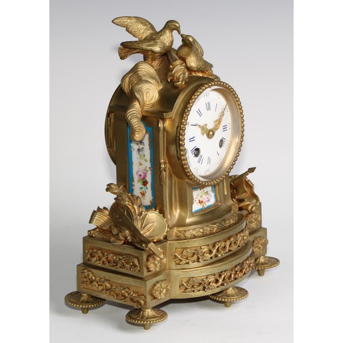 1754 - A French gilt brass mantel clock, crested with a pair of lovebirds and flaming torch, the white enam... 