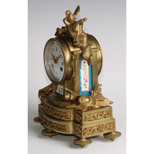 1754 - A French gilt brass mantel clock, crested with a pair of lovebirds and flaming torch, the white enam... 