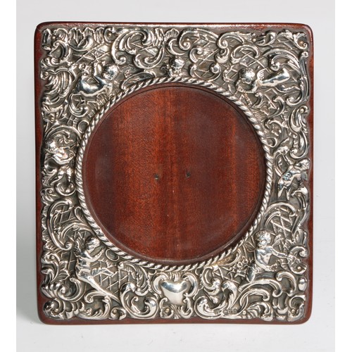 1165 - An Edwardian silver easel photograph frame, embossed with putti and scrolling acanthus, 17cm high, J... 