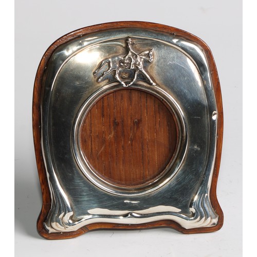 1135 - An Art Nouveau silver easel photograph frame, of equestrian interest, applied with a horse and rider... 