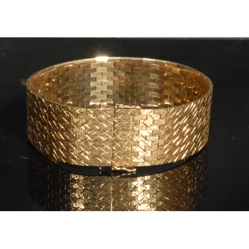 1330 - A 9ct gold flat brick link articulated bracelet, engraved with flashes against a matt ground, makers... 