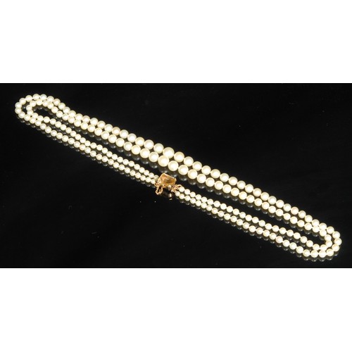 1531 - Tallulah Bankhead - A two strand graduated pearl necklace, the clasp stamped '14K' for 14ct, set wit... 