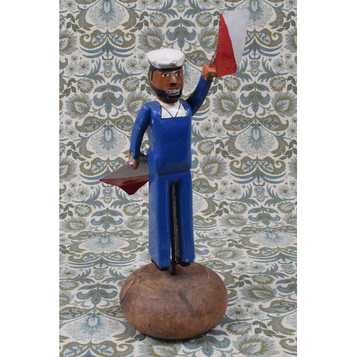 6070A - Folk Art - a carved and painted wooden whirligig toy, in the form of a maritime signalman in blue un... 