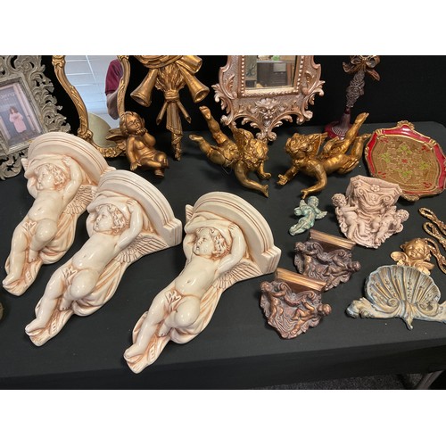 38 - Interior design - three ceramic Cherub wall brackets, an ornate gilt looking glass;  rococo style fr... 