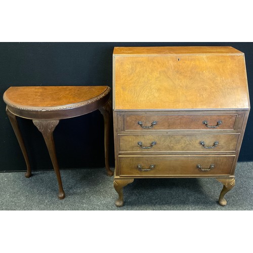 110 - A reproduction walnut veneer bureau, fall door to top enclosing fitted interior, above three graduat... 