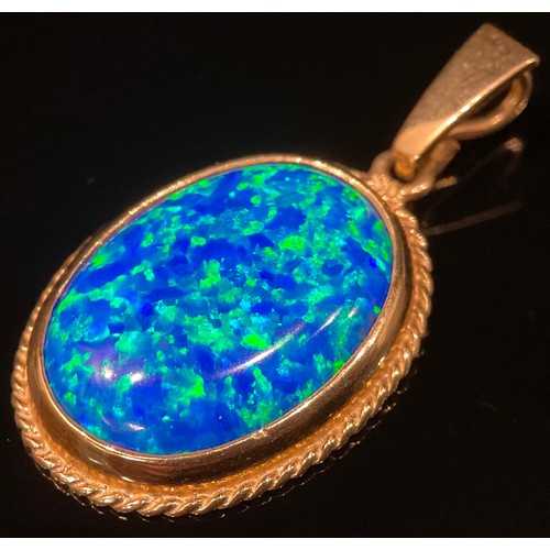 521 - A deep blue stone oval pendant, possibly an opal, flashing vey vibrant blue green tones, 9ct gold mo... 