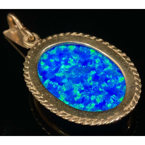 521 - A deep blue stone oval pendant, possibly an opal, flashing vey vibrant blue green tones, 9ct gold mo... 