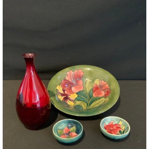 11 - A Moorcroft hibiscus pattern bowl, 25cm diameter, mark on base; two trinket dishes; an ovoid Doulton... 