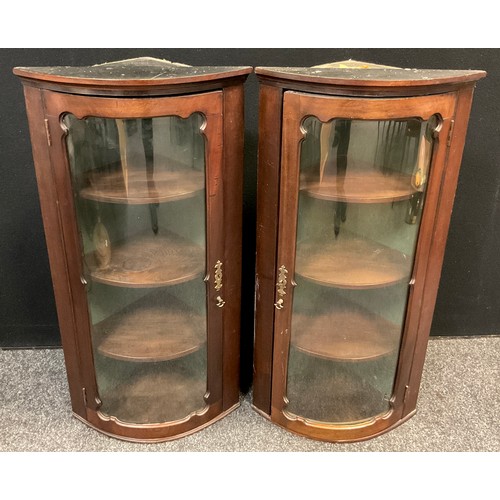 45 - A pair of Edwardian mahogany bow front corner cabinets, wall mountable, of narrow proportions, each ... 