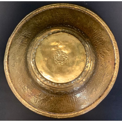 73 - A 19th century Persian brass dish, engraved, embossed and chased with animals and text, 36cm in diam... 